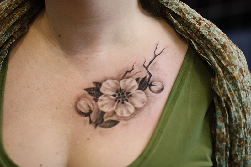 Небольшая татуировка цветок на груди