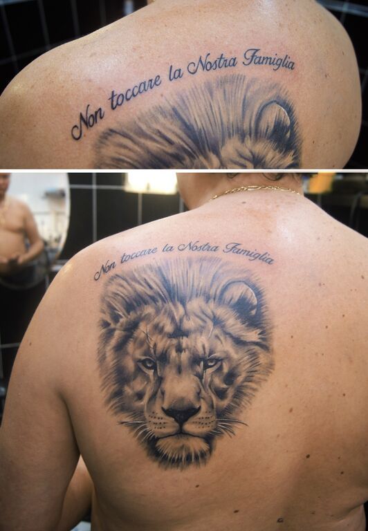 Тату лев с надписью на спине