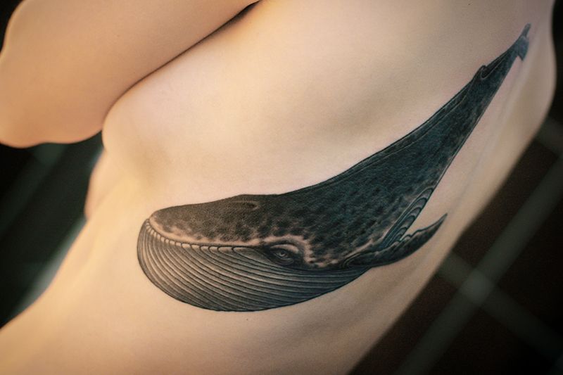 Татуировка кит на ребрах.