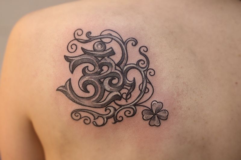 Татуировки с символом Ом, духовность на коже