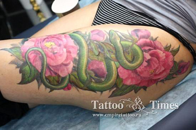 Татуировка Змея с пионами на бедре