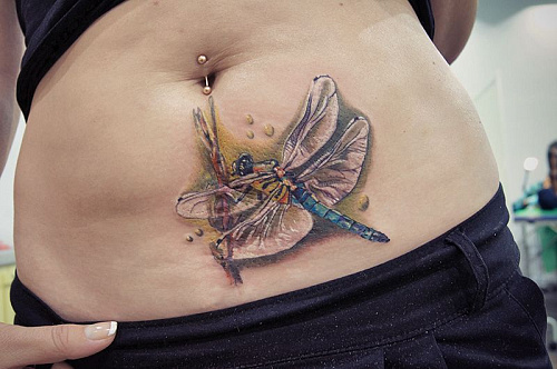 Тату стрекоза на животе на шраме