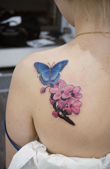 Женская тату голубая бабочка с сакурой