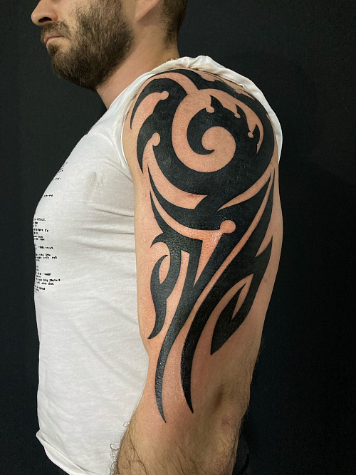 Тату в стиле трайбл на плече